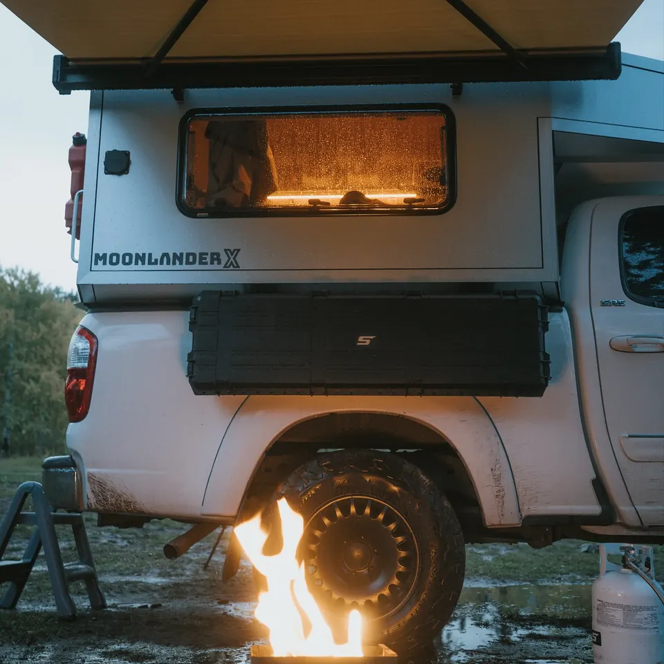 Truck camper parked at camp with vehicle gear in use