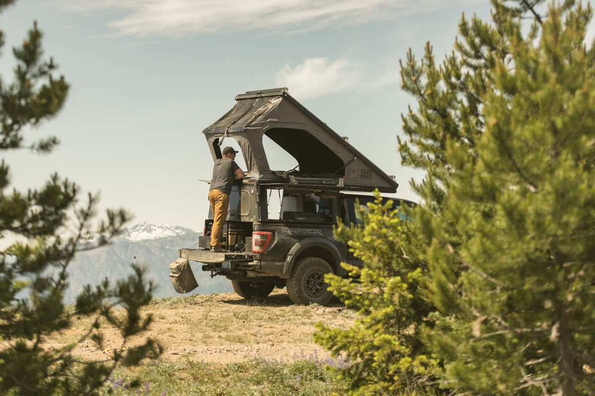 Truck camper parked outdoors with mountain terrain