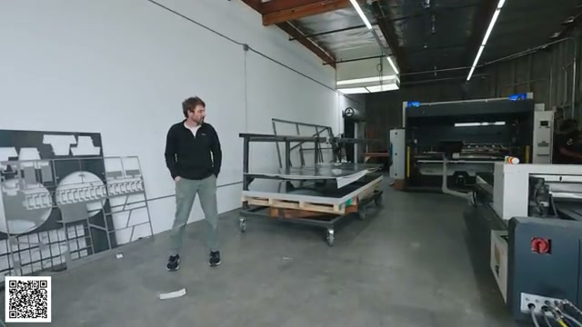Thomas from Topo Toppers standing beside sheet aluminum near the laser-cutting station
